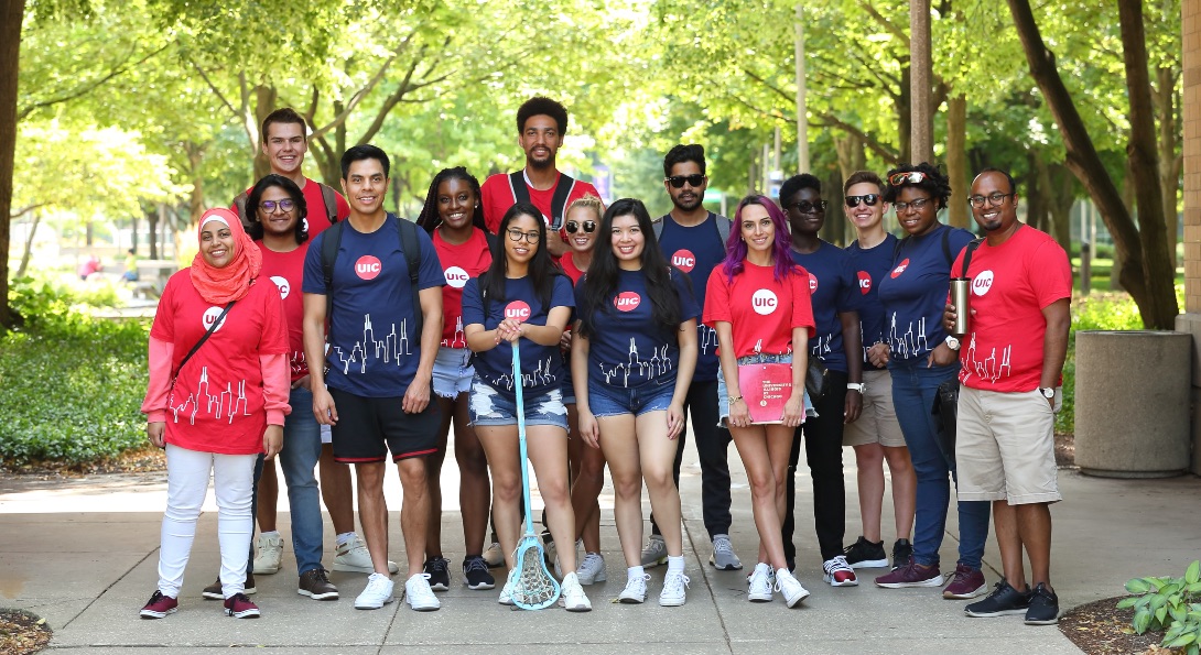 UIC Students, Smiling and standing in front of the campus entrance.