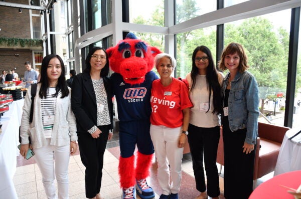 Chancellor and Sparky standing with new faculty